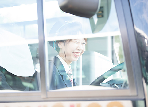 女性社員が運転席から笑っている写真